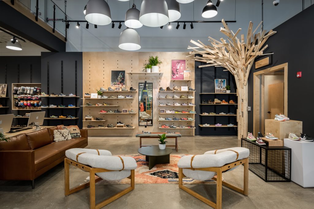 Seating area and fitting rooms with shoe sales inside Backcountry Chicago.