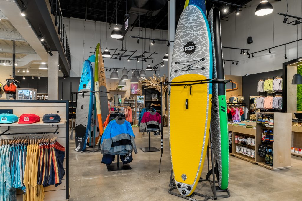 Interior of Backcountry retail store with surfboards and canoes.