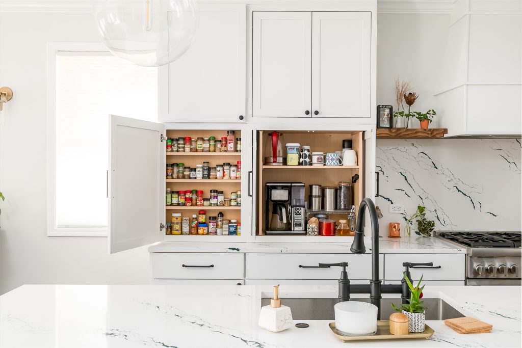 Detail of cabinet organization and appliance garage in modern white kitchen renovation