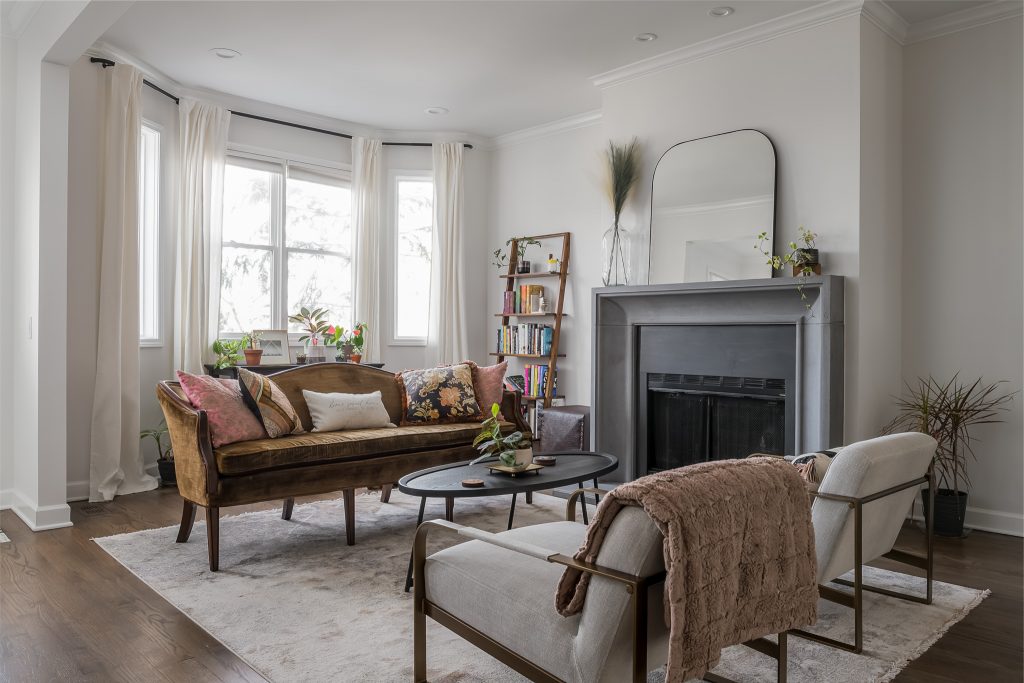 Moody transitional living room with bold dark fireplace and mid century modern furniture