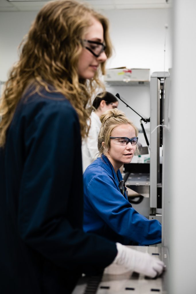Two female scientists confer on laboratory findings
