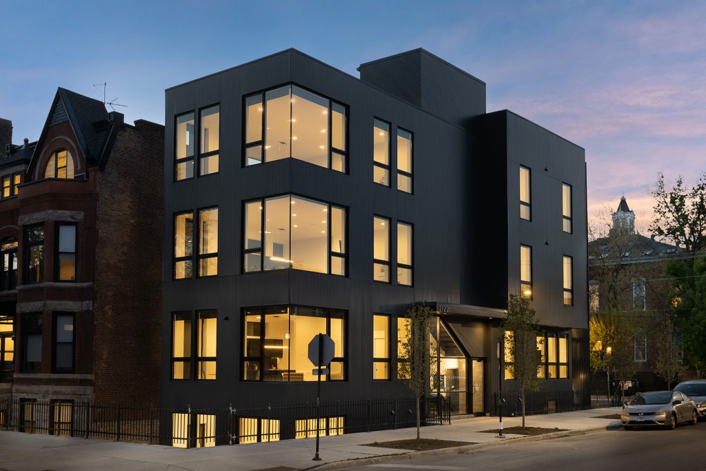 Modern Multi-unit Building with black exterior in Pilsen at Twiglight with lights on