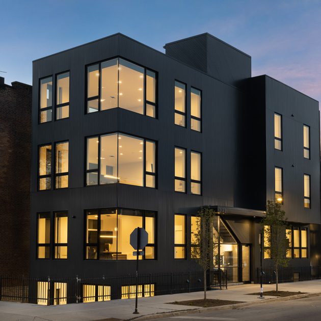 Modern Multi-unit Building with black exterior in Pilsen at Twiglight with lights on