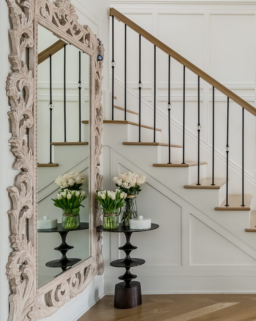 Transitional staircase with large mirror in entryway.