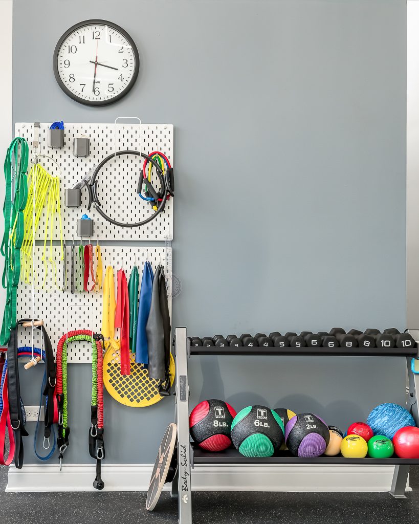 A variety of gym equipment organized at a physical therapy office.