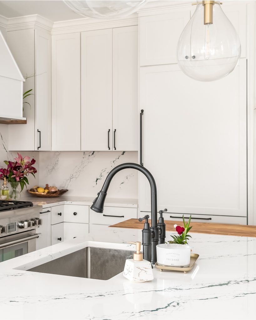 Close up of black matte sink fixtures in all white kitchen