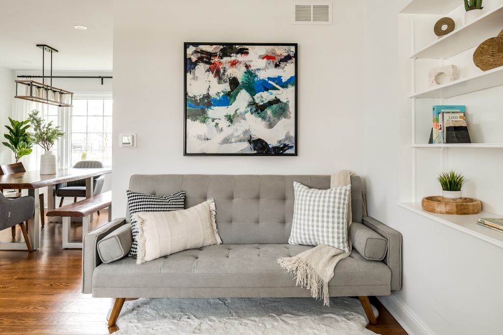 Image of a neutral gray couch with bold artwork