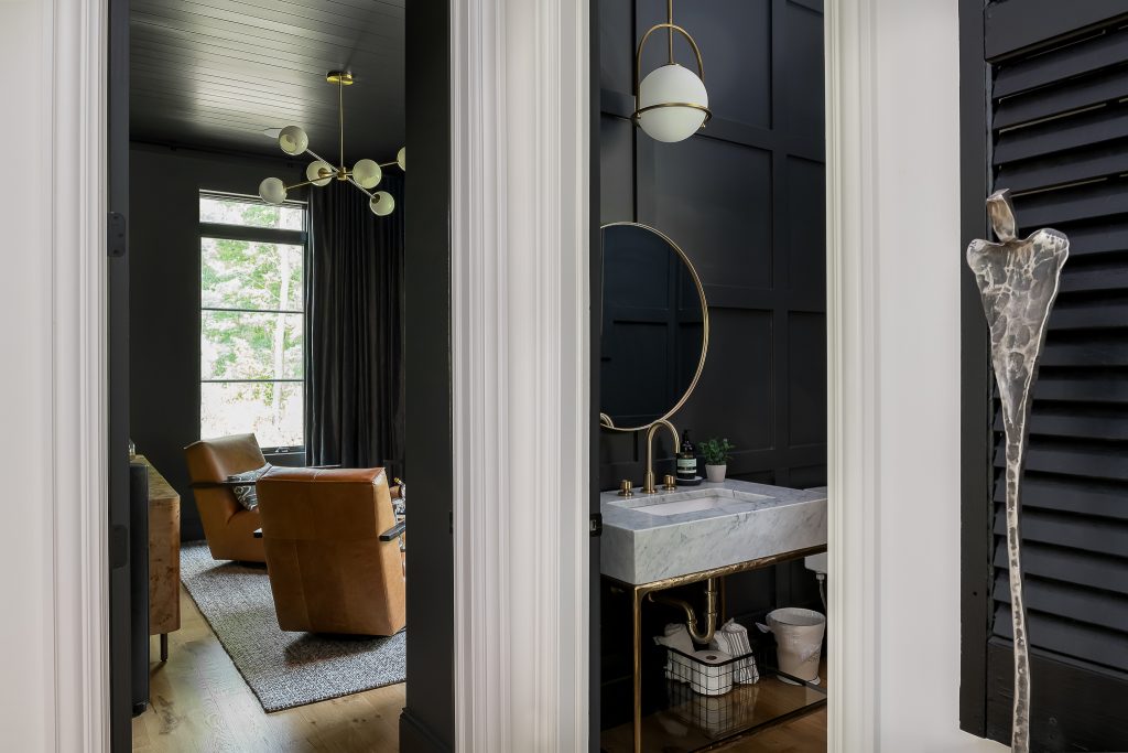 Hallway view of moody powder room and custom speakeasy.
