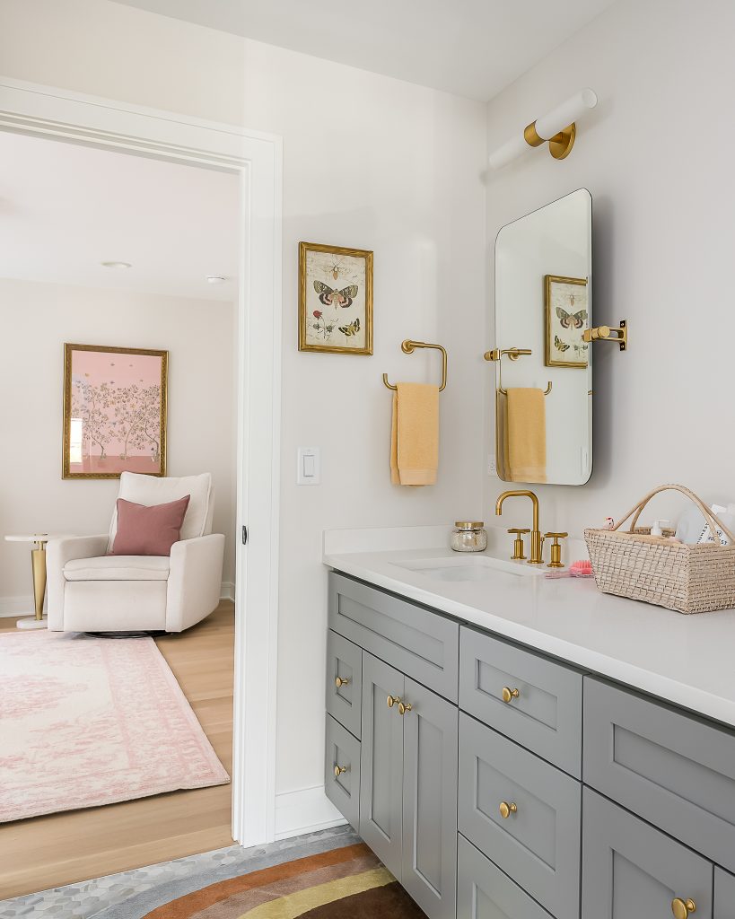Modern children's bathroom with gray vanity and metallic details.