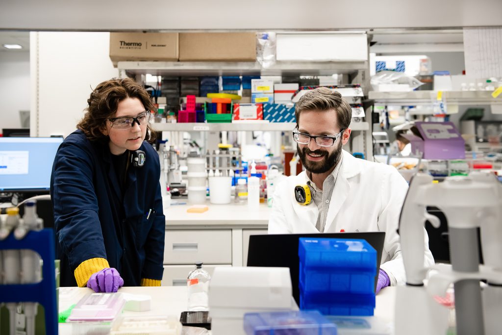 Two scientists view lab results on computer