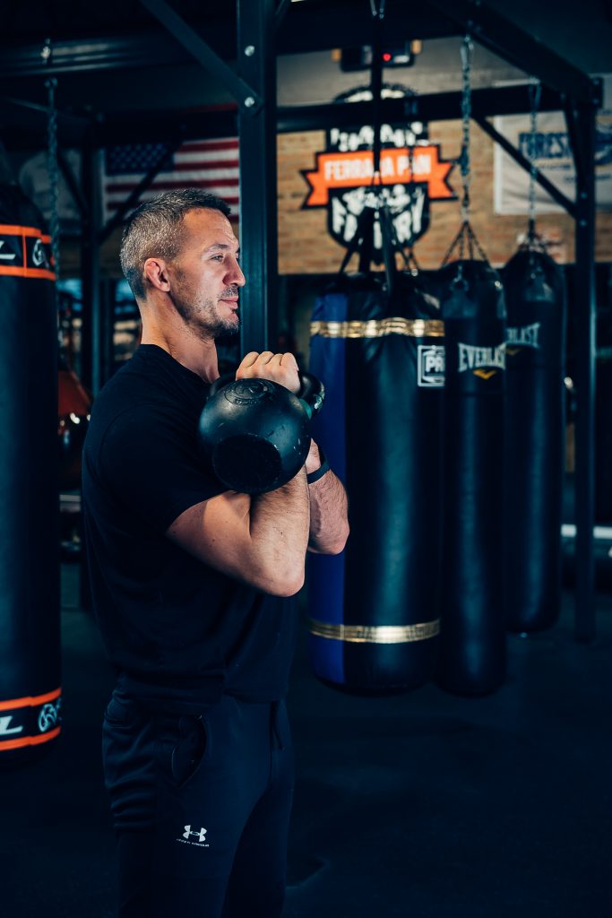 Personal trainer demonstrates proper form of kettle bell