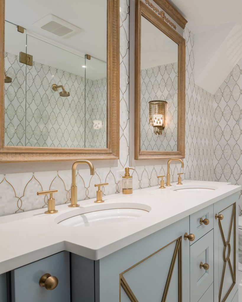 Modern glam bathroom with powder blue cabinets and gold hardware